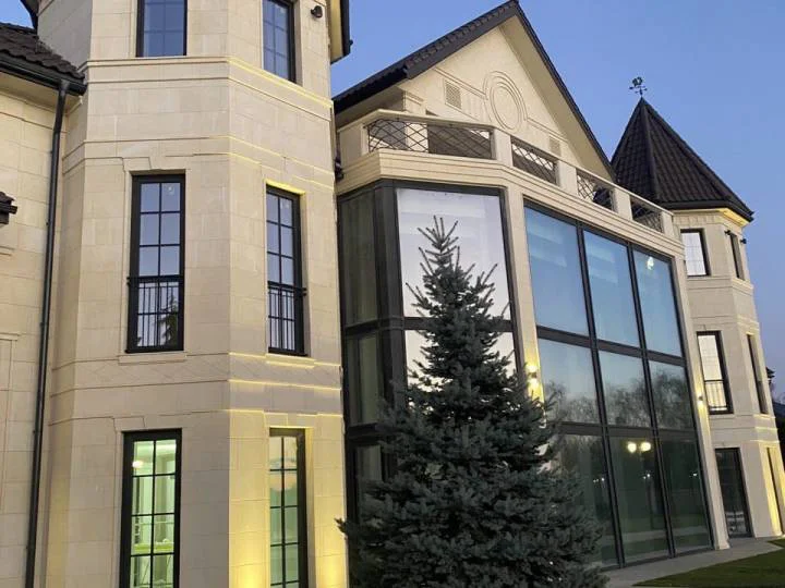 A modern residential or commercial building featuring a distinctive combination of traditional architectural elements and large glazed sections.