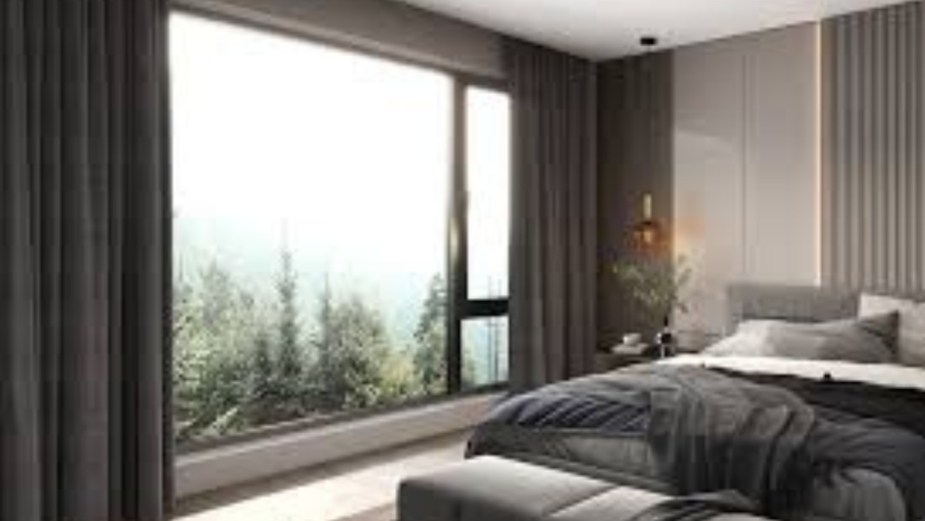 Cozy modern bedroom with large aluminium bedroom windows offering a serene forest view and natural daylight.