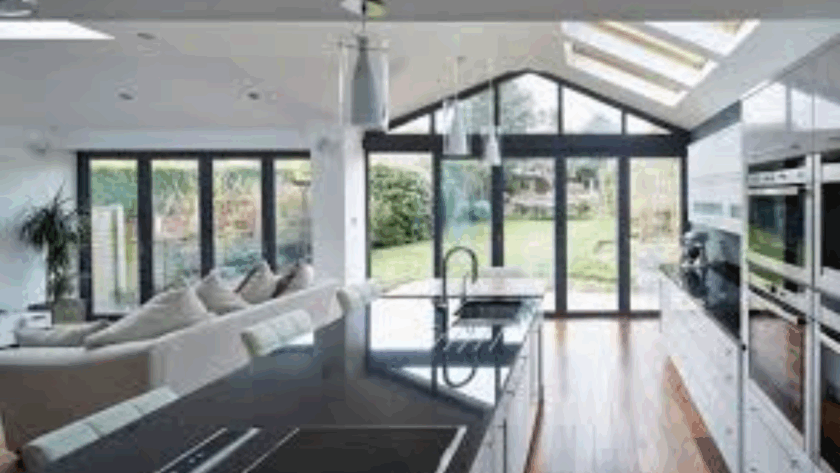 Open-plan kitchen and living area with floor-to-ceiling tilt and turn triple glazed windows, offering full natural light and modern energy efficiency