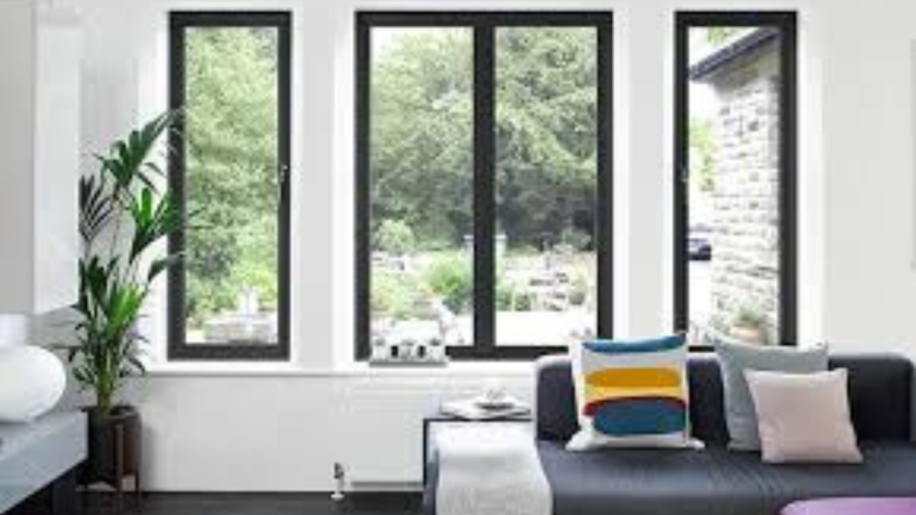 Living room with black aluminium windows overlooking a green garden, combining style and modern functionality.