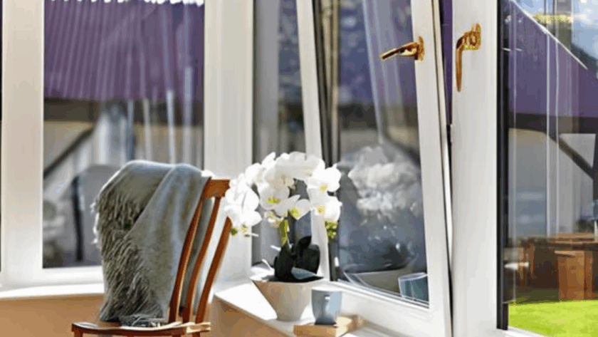 Bright modern interior with white tilt and turn windows, a wooden chair, and potted white flowers on the windowsill