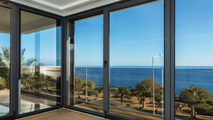 Large custom made aluminium windows overlooking the sea, enhancing style and providing panoramic views