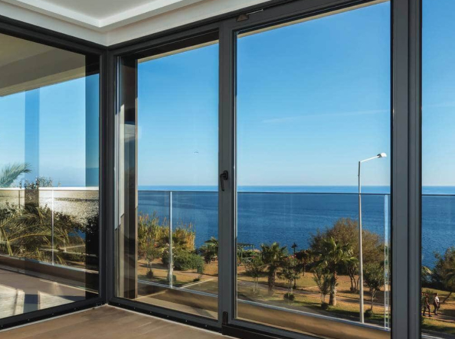 Large custom made aluminium windows overlooking the sea, enhancing style and providing panoramic views