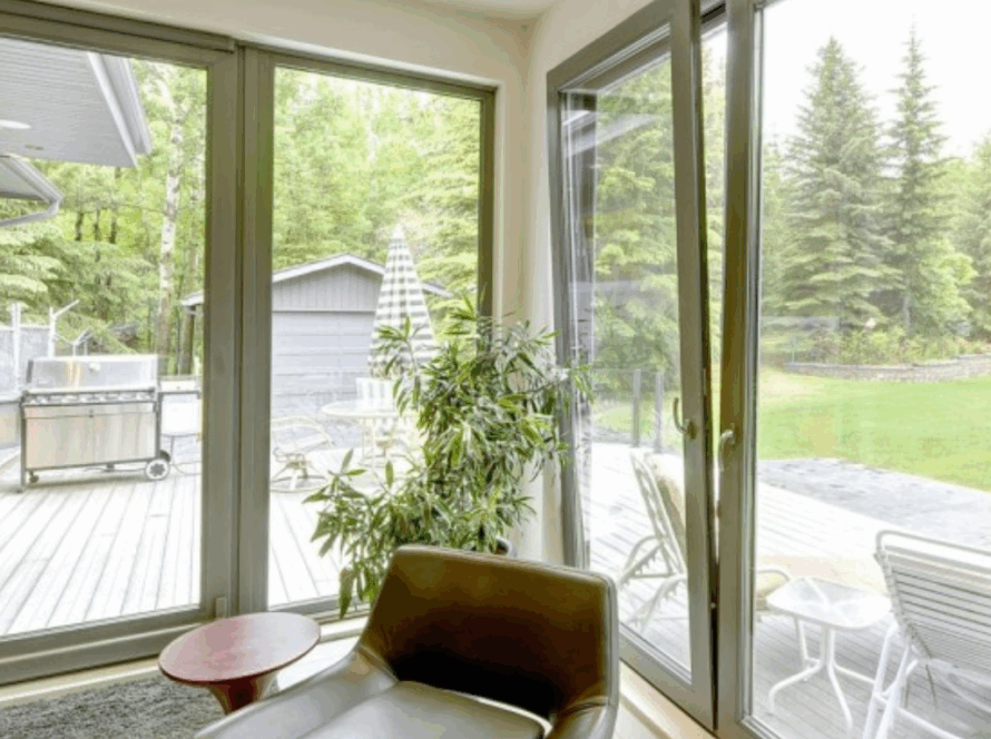 Contemporary interior with large European tilt and turn windows, offering stunning garden views, enhanced energy efficiency, and elegant modern style
