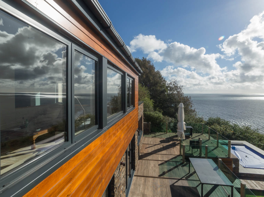 Sleek modern aluminium windows reflecting ocean views on a contemporary coastal home
