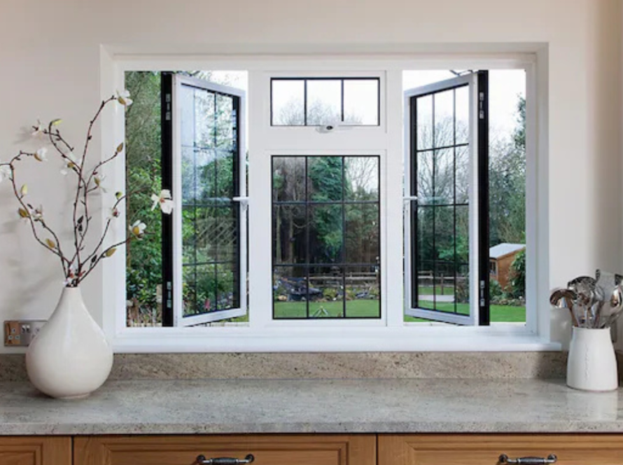 Kitchen interior with open white aluminium windows and classic white window frames overlooking a green backyard.