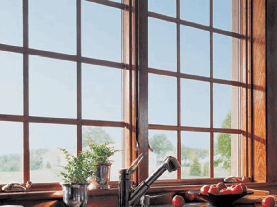 Wooden 400 series casement window with grilles, offering a clear view of the landscape and natural light into the kitchen