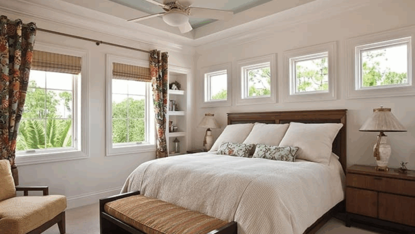White-frame bedroom casement windows above and beside a bed, bringing in natural light and greenery