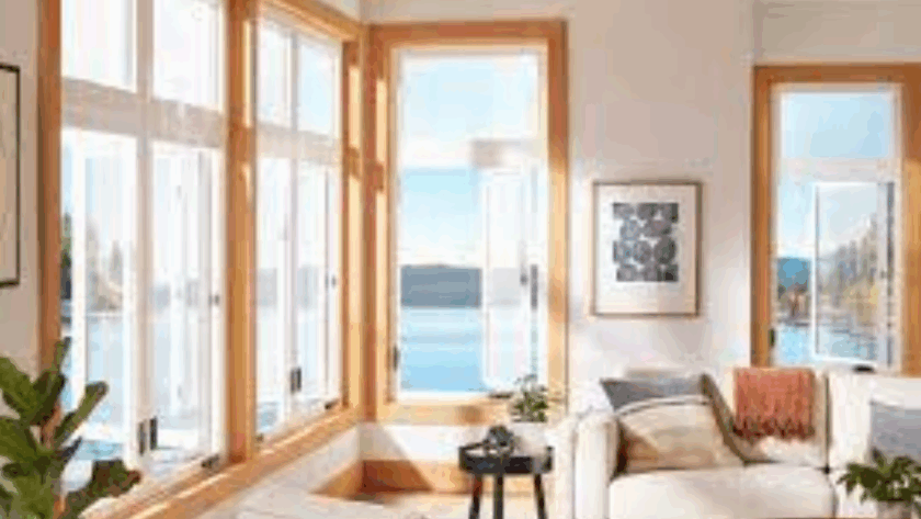 Casement windows with natural wood frames in a newly constructed living space overlooking a lake