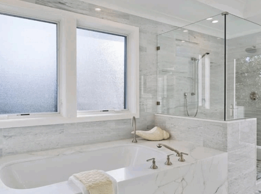 Elegant bathroom interior with privacy glass casement windows above a luxurious marble bathtub