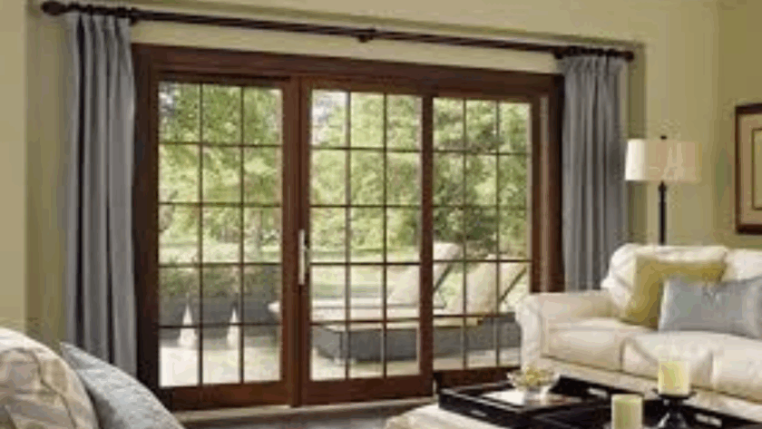 Elegant wooden French sliding windows overlooking a comfortable garden patio from a cozy living room