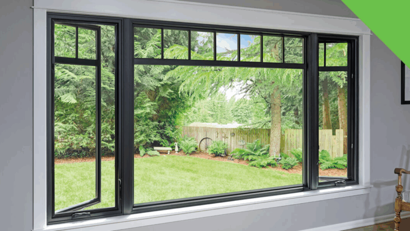 Black-framed large casement windows with side openings and top transom panels, offering a view of a green backyard with trees and a fence