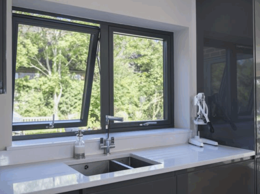 Modern kitchen featuring stylish top hung casement windows overlooking a green backyard