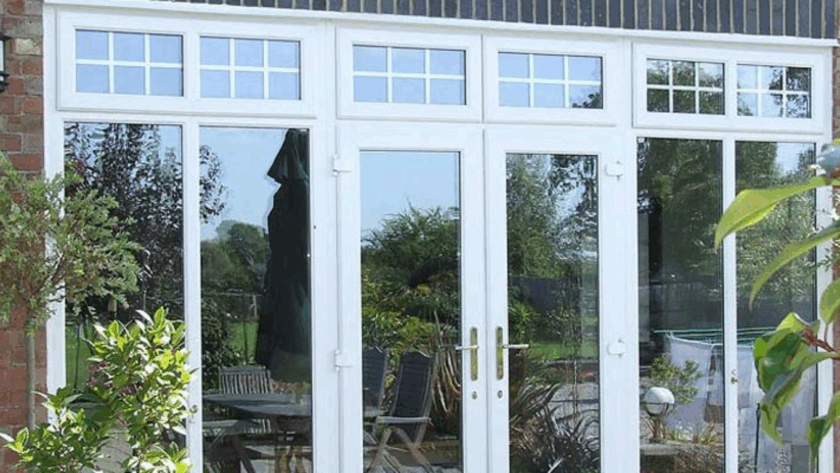 Classic white uPVC French-style windows opening to a green garden patio