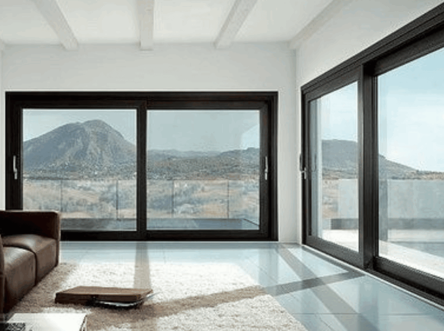Spacious modern living room featuring large aluminum casement windows with stunning mountain views