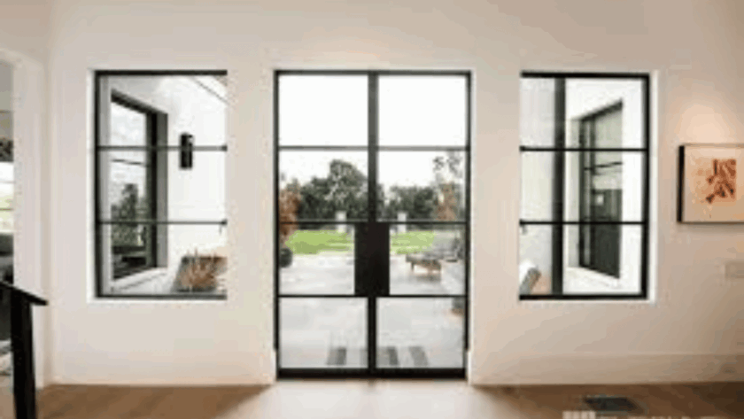 Modern black metal casement window replacement overlooking a garden patio