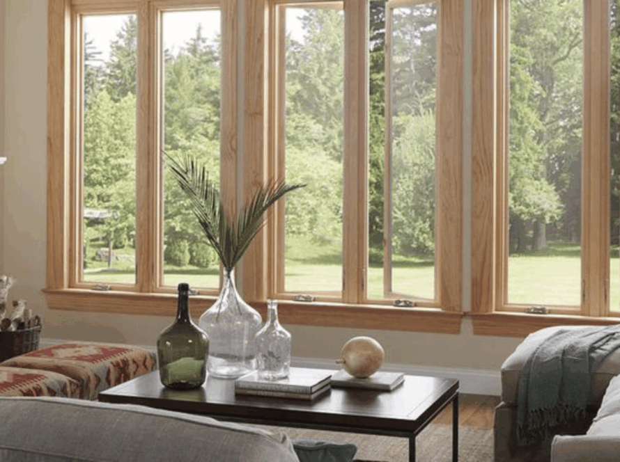 Wood-framed casement windows overlooking a serene green backyard from an elegant living room