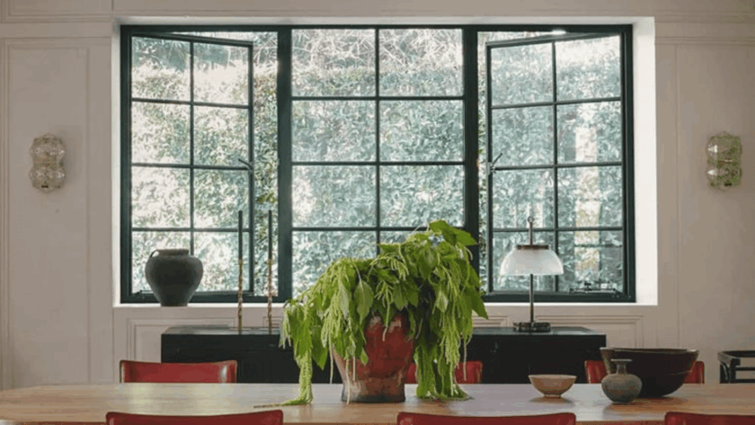 Elegant black aluminum casement windows opening to a lush green garden view