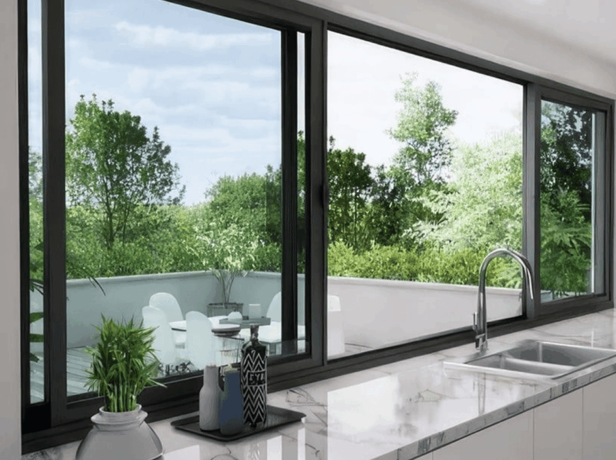 Contemporary kitchen interior with elegant side sliding windows overlooking a vibrant green outdoor terrace