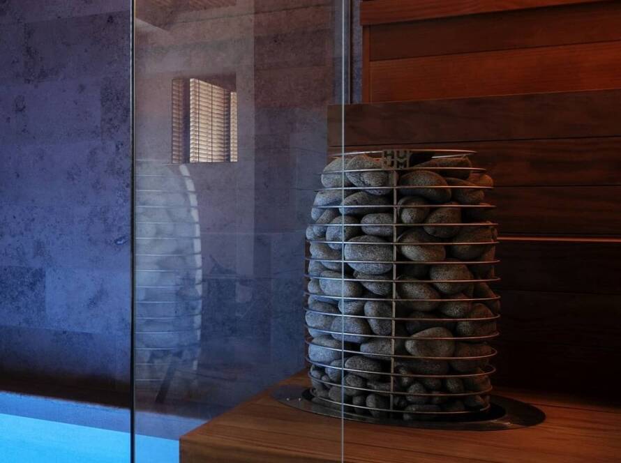 HUUM HIVE Mini electric sauna heater installed in a wood-lined sauna room