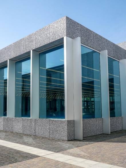 Modern commercial building with large vertical double glazing window units framed in sleek metal structures, offering enhanced insulation and a clean architectural look.