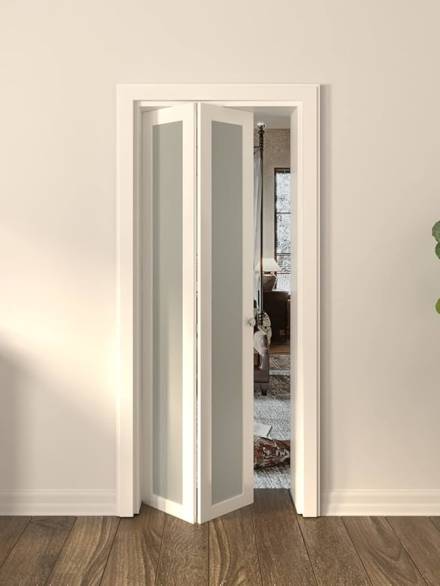 White aluminium folding doors with frosted glass panels installed in a narrow doorway of a modern interior.