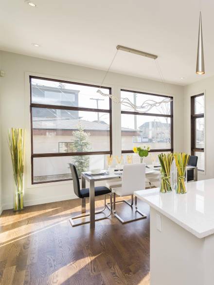 Modern dining area featuring large triple glazing window units that enhance energy efficiency while maximizing natural light and outdoor visibility.