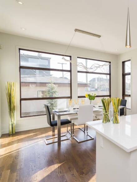 Modern dining area featuring large triple glazing window units that enhance energy efficiency while maximizing natural light and outdoor visibility.