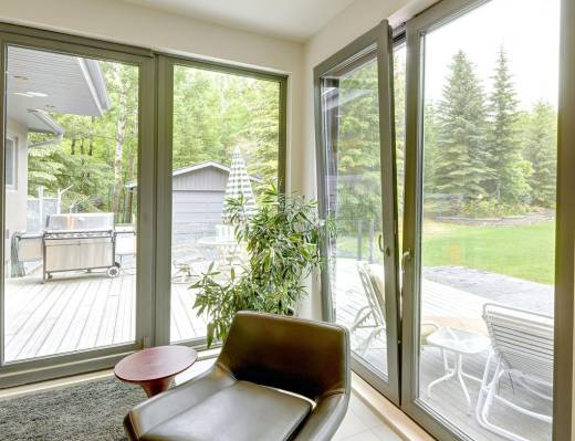Bright living space with large aluminium tilt and turn windows and doors, offering a seamless view to the green backyard.
